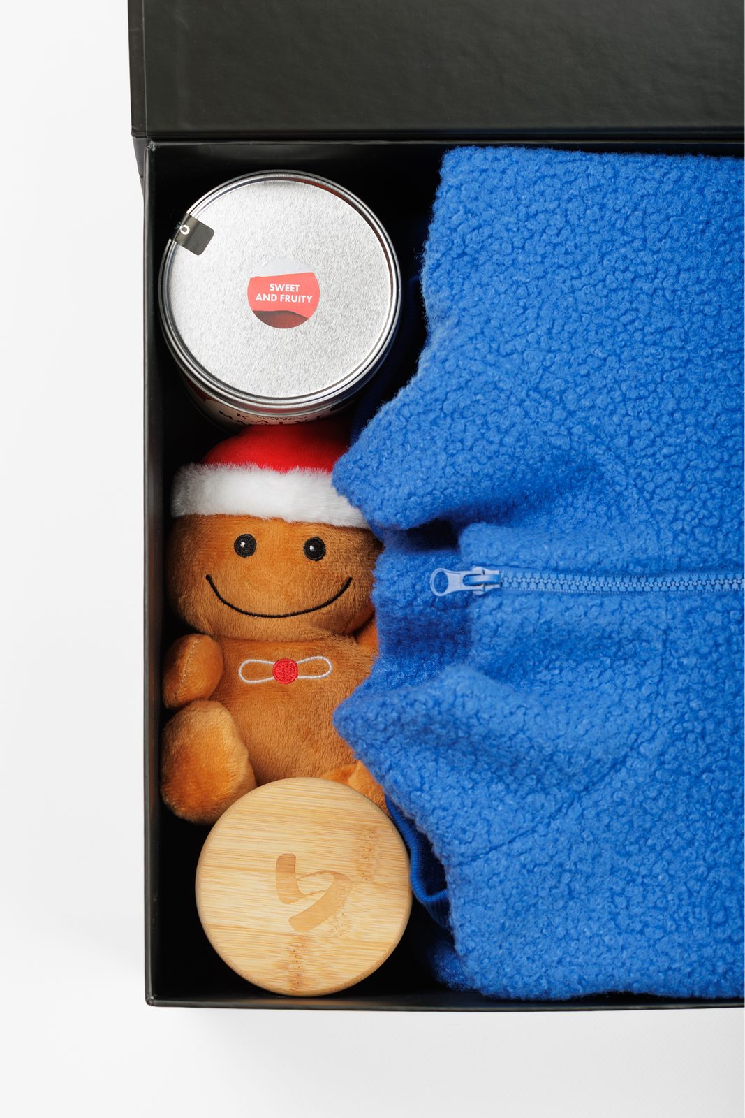 Christmas gift box with a blue teddy item, coffee and a gingerbread plush toy